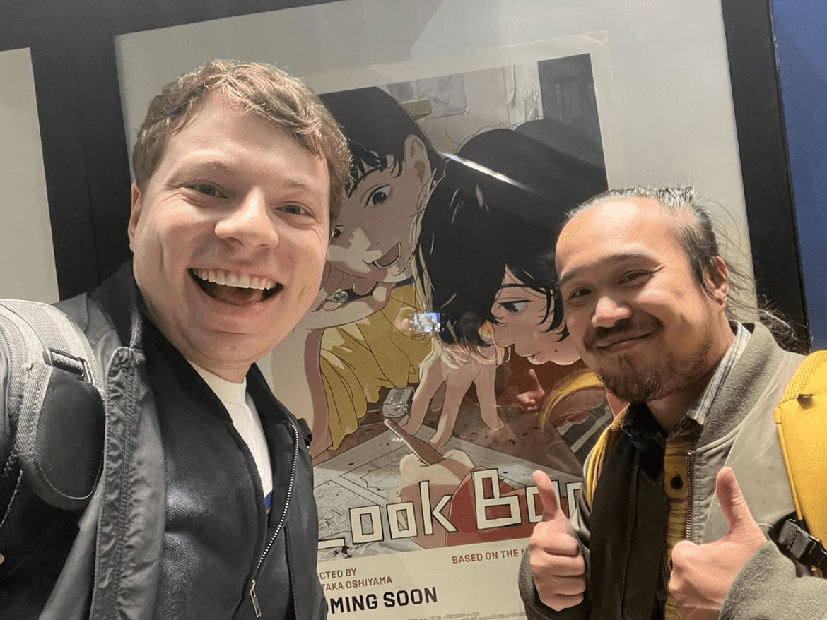 Selfee of two guys with a poster for Look Back