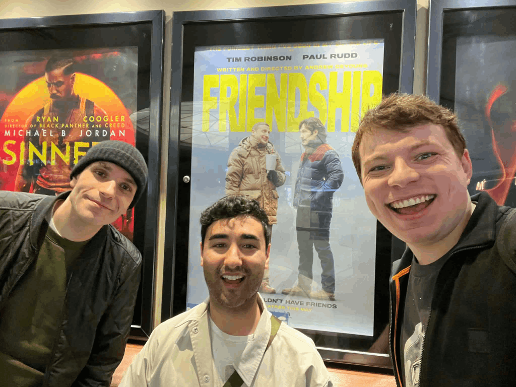 Selfie of three friends with a poster for Friendship